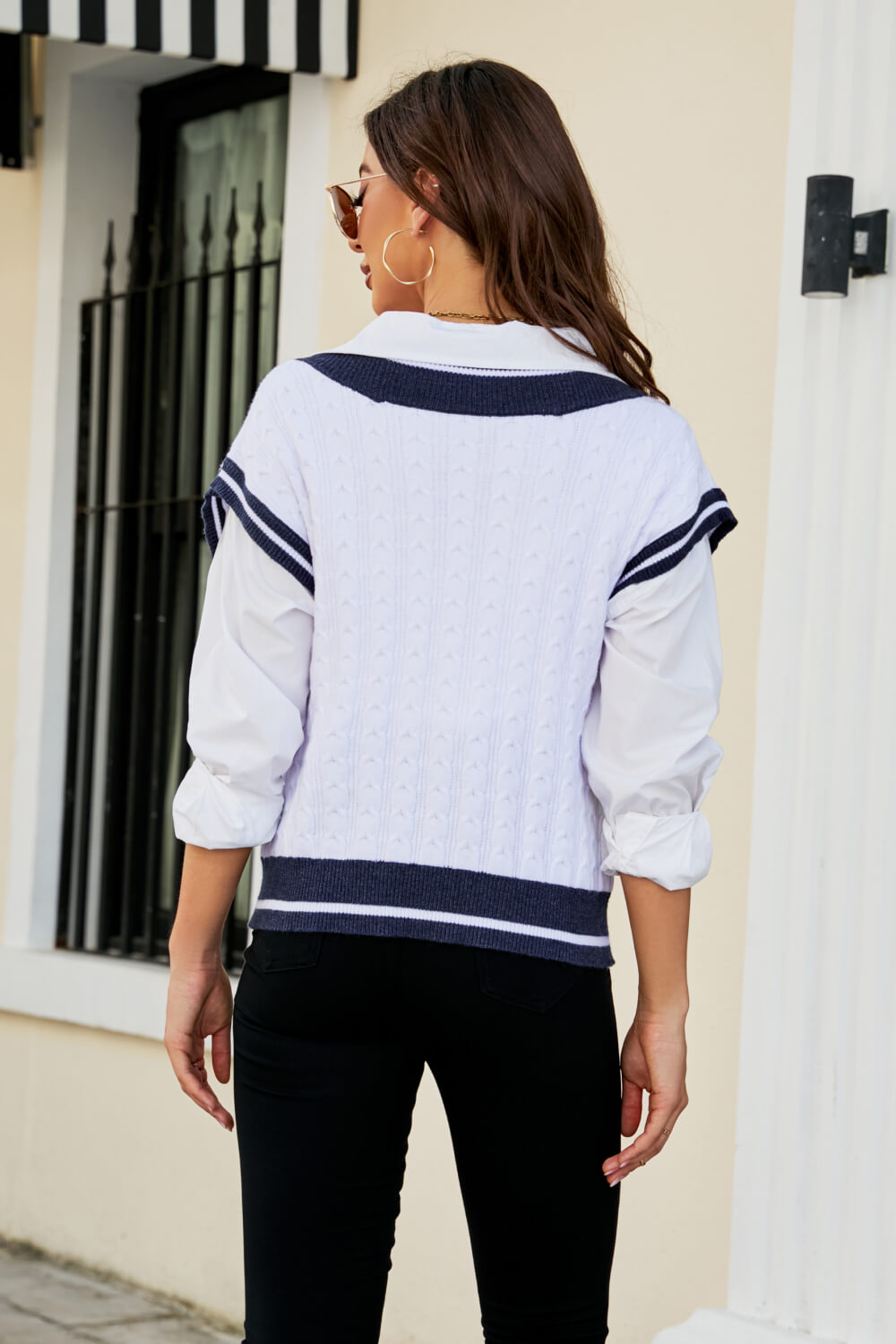 A stylish Contrast V-Neck Cap Sleeve Sweater Vest displayed outdoors, featuring a chic design with a contrast pattern and cap sleeves.