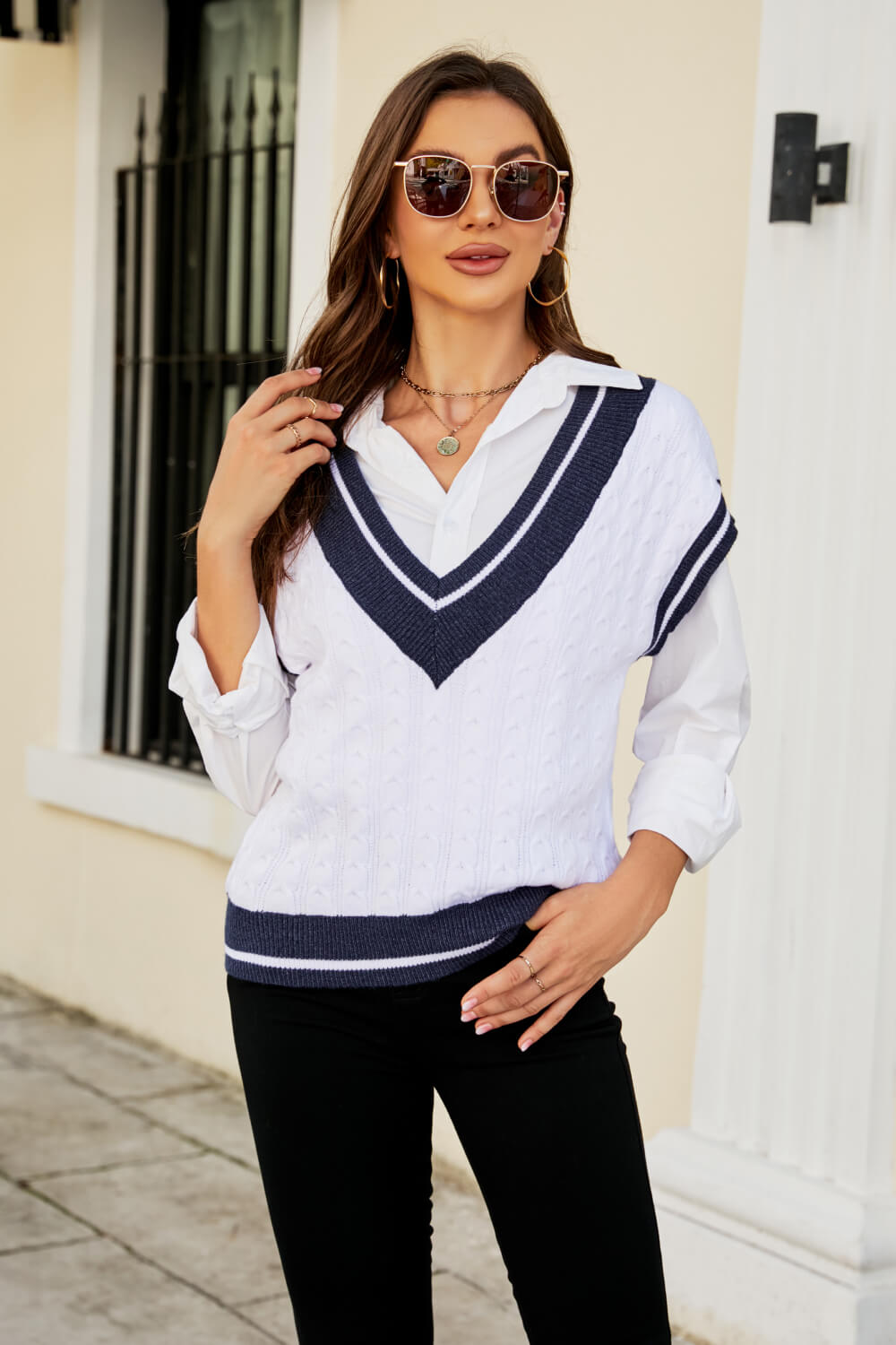 A stylish Contrast V-Neck Cap Sleeve Sweater Vest displayed outdoors, featuring a chic design with a contrast pattern and cap sleeves.