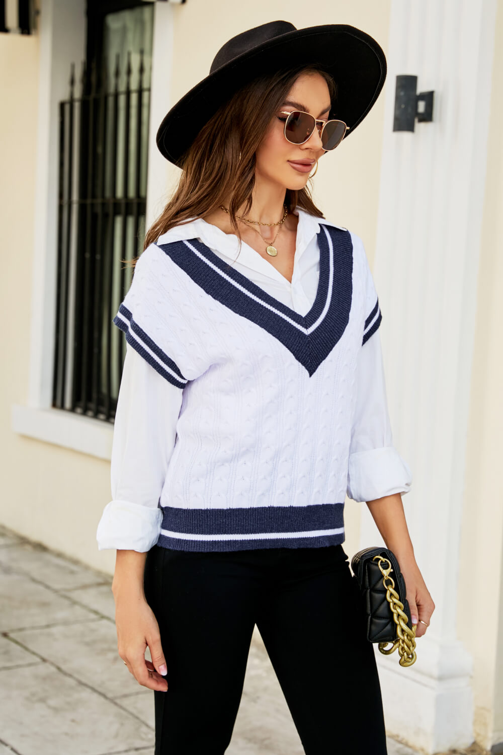 A stylish Contrast V-Neck Cap Sleeve Sweater Vest displayed outdoors, featuring a chic design with a contrast pattern and cap sleeves.