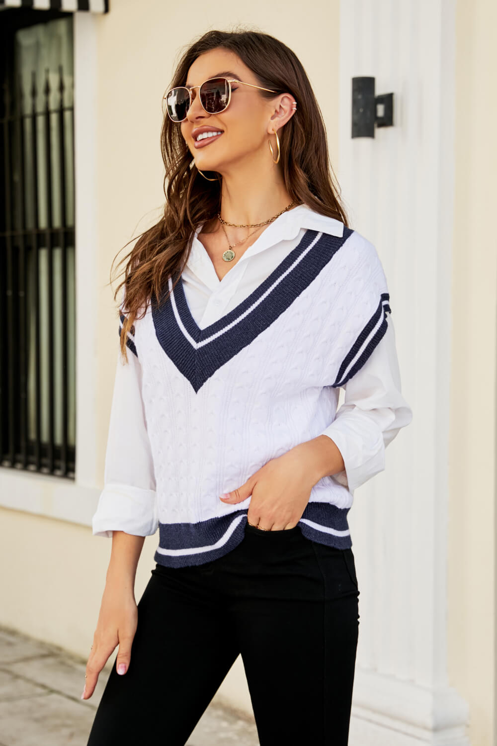 A stylish Contrast V-Neck Cap Sleeve Sweater Vest displayed outdoors, featuring a chic design with a contrast pattern and cap sleeves.