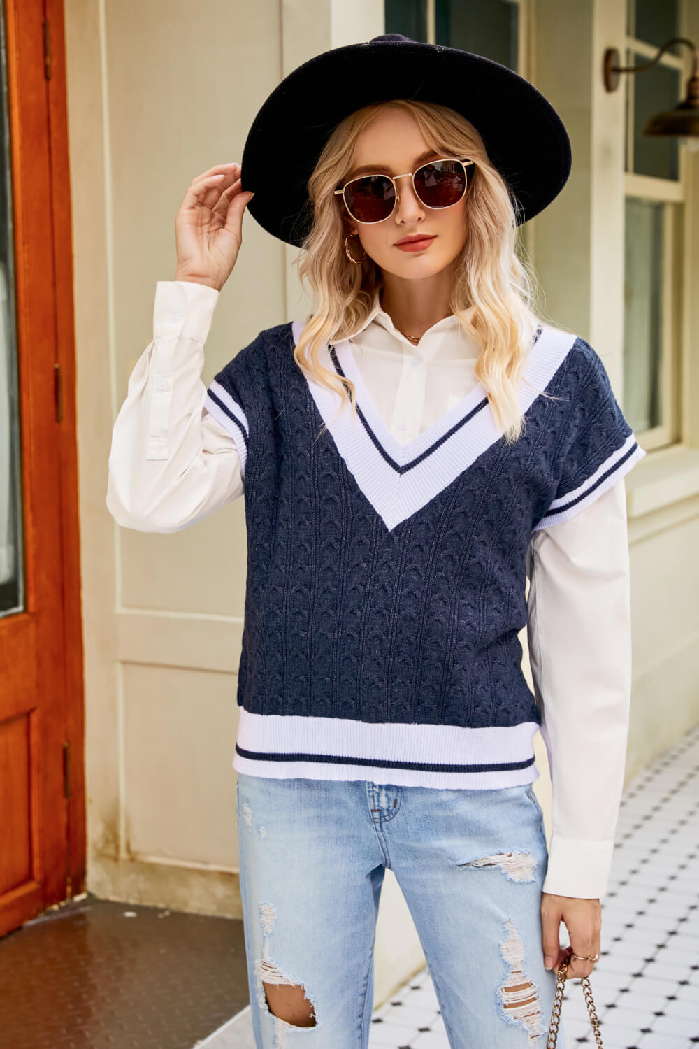 A stylish Contrast V-Neck Cap Sleeve Sweater Vest displayed outdoors, featuring a chic design with a contrast pattern and cap sleeves.