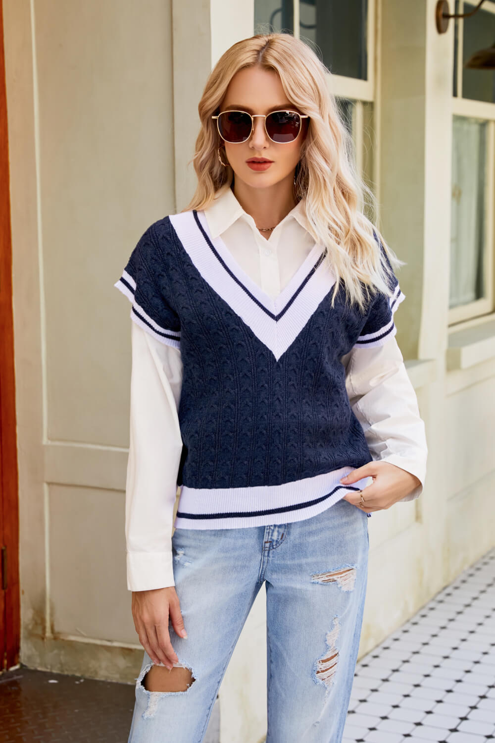 A stylish Contrast V-Neck Cap Sleeve Sweater Vest displayed outdoors, featuring a chic design with a contrast pattern and cap sleeves.