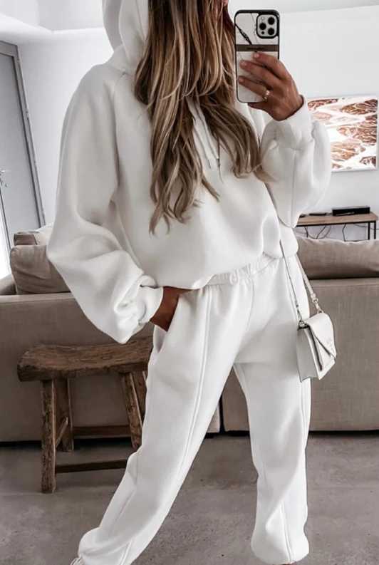 White cotton tracksuit set featuring a loose sweatshirt with a hoodie and long pants, designed for comfort and style.