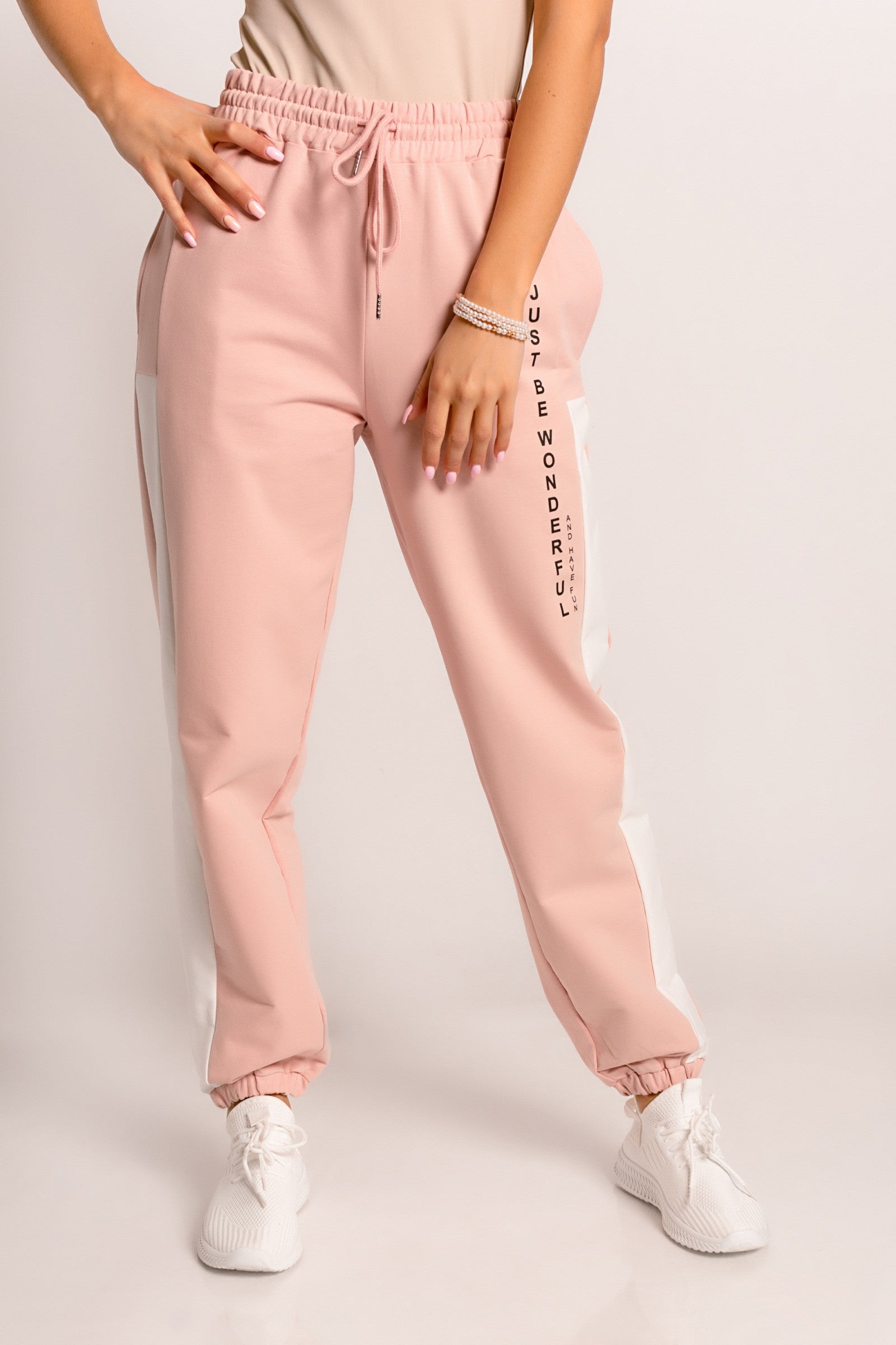 Light pink cotton trousers with decorative print and elastic waist, perfect for sports and leisure activities.