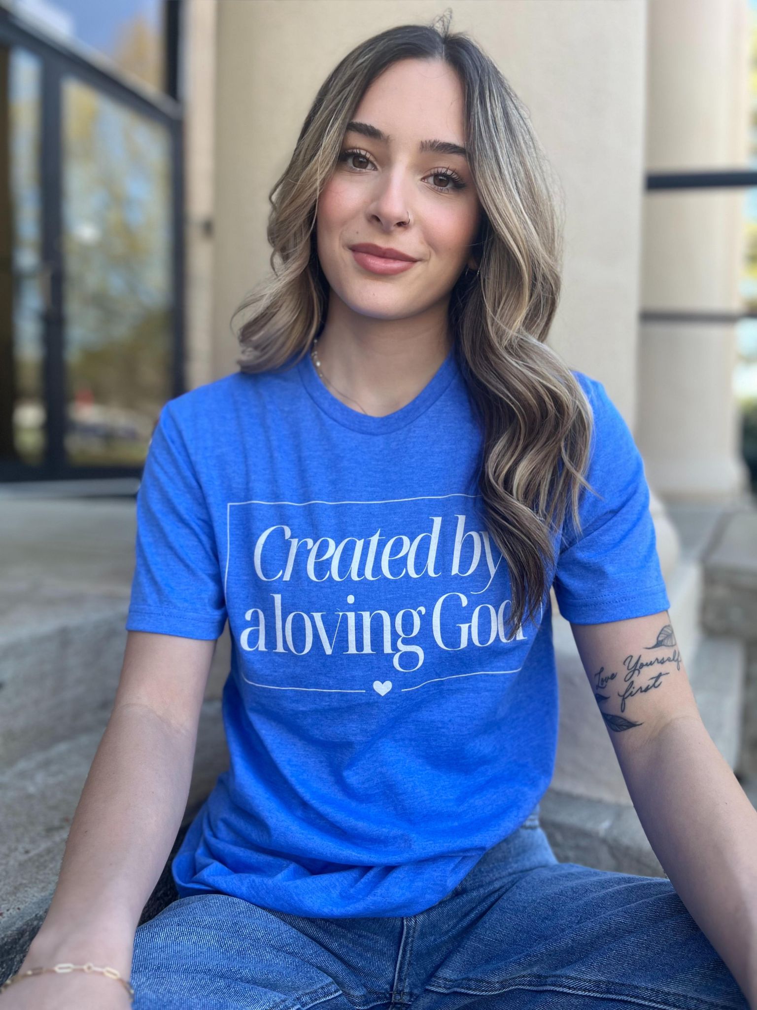 A stylish Heather Royal tee with the phrase 'Created by A Loving God' printed on it, showcasing a comfortable fit.