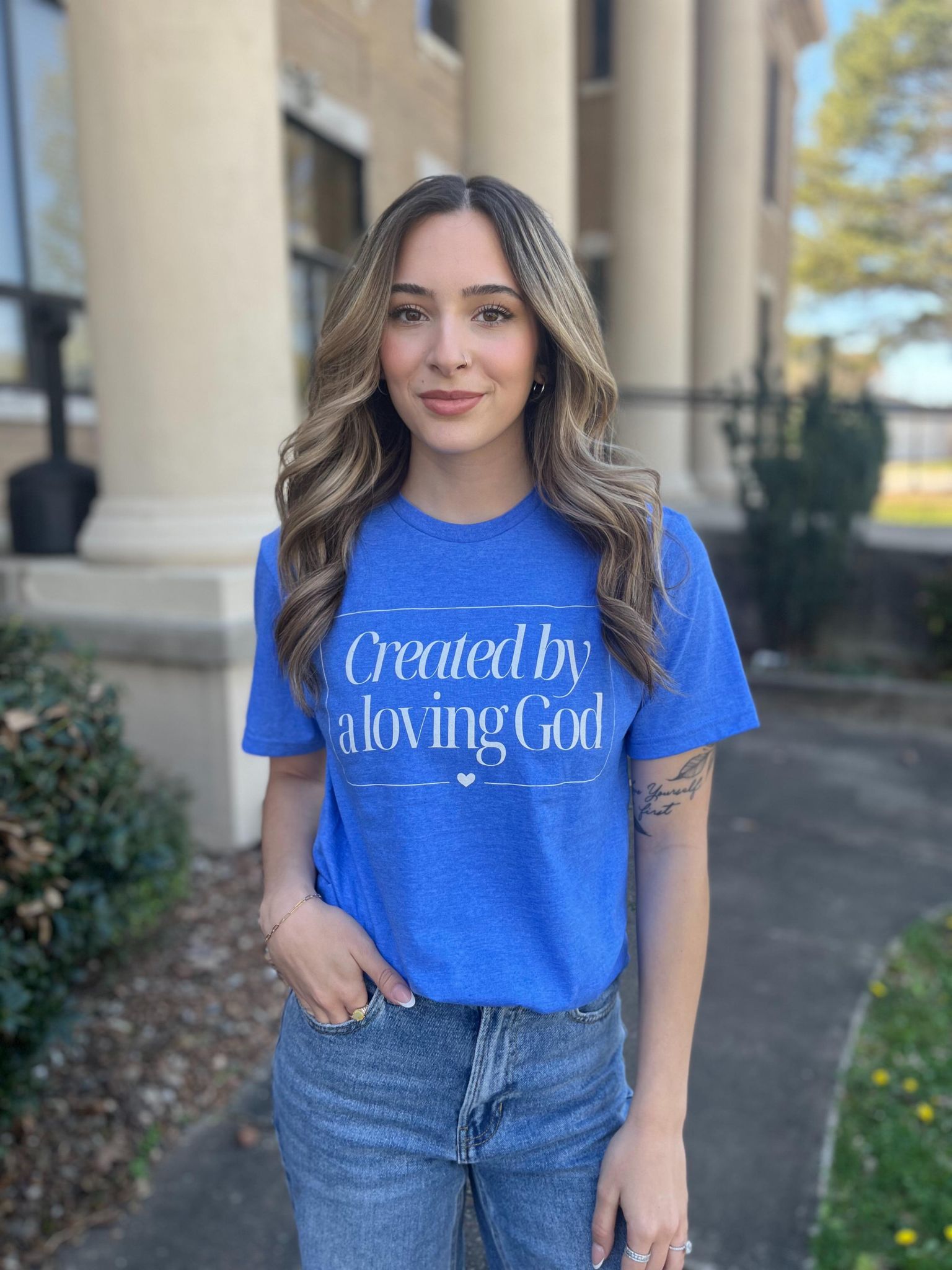 A stylish Heather Royal tee with the phrase 'Created by A Loving God' printed on it, showcasing a comfortable fit.