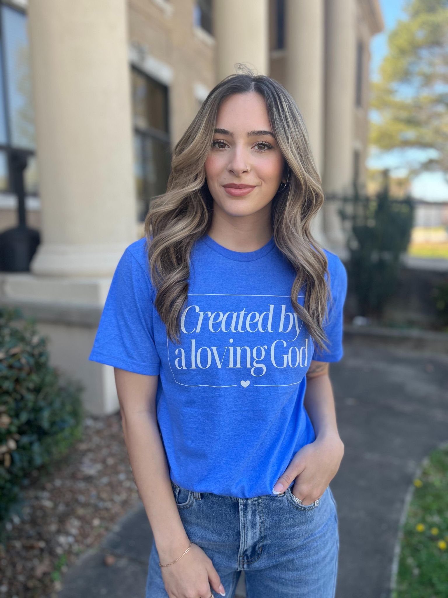 A stylish Heather Royal tee with the phrase 'Created by A Loving God' printed on it, showcasing a comfortable fit.