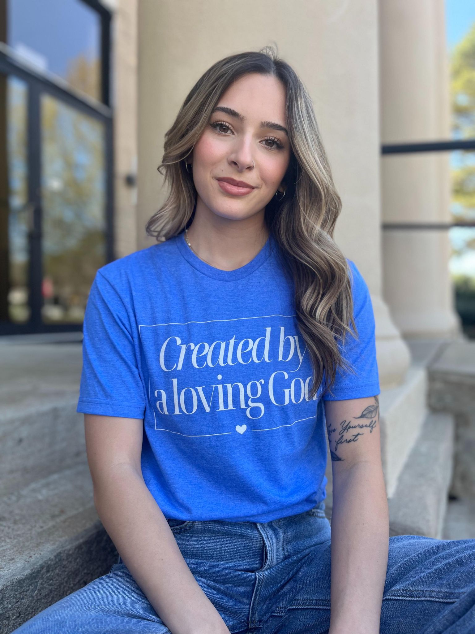 A stylish Heather Royal tee with the phrase 'Created by A Loving God' printed on it, showcasing a comfortable fit.