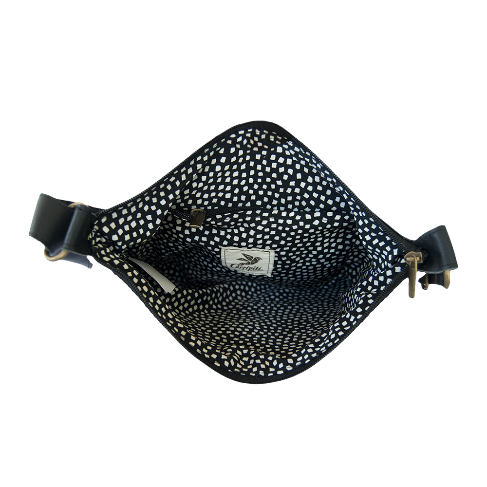 Brown leather cross-body bag featuring coral and green woven stripe, showcasing ethnic motifs and adjustable strap.