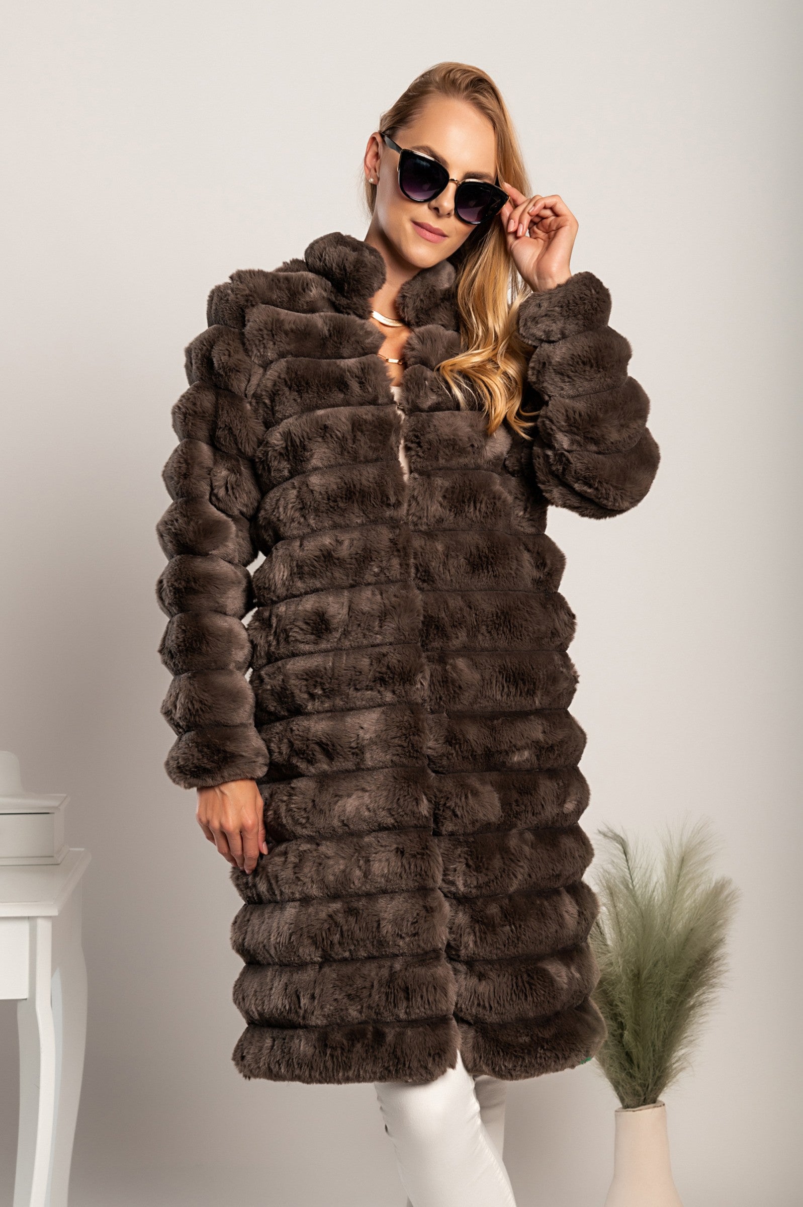 Daljši eleganten plašč iz umetnega krzna Benimia v rjavi barvi, z visokim ovratnikom in dvema žepoma.