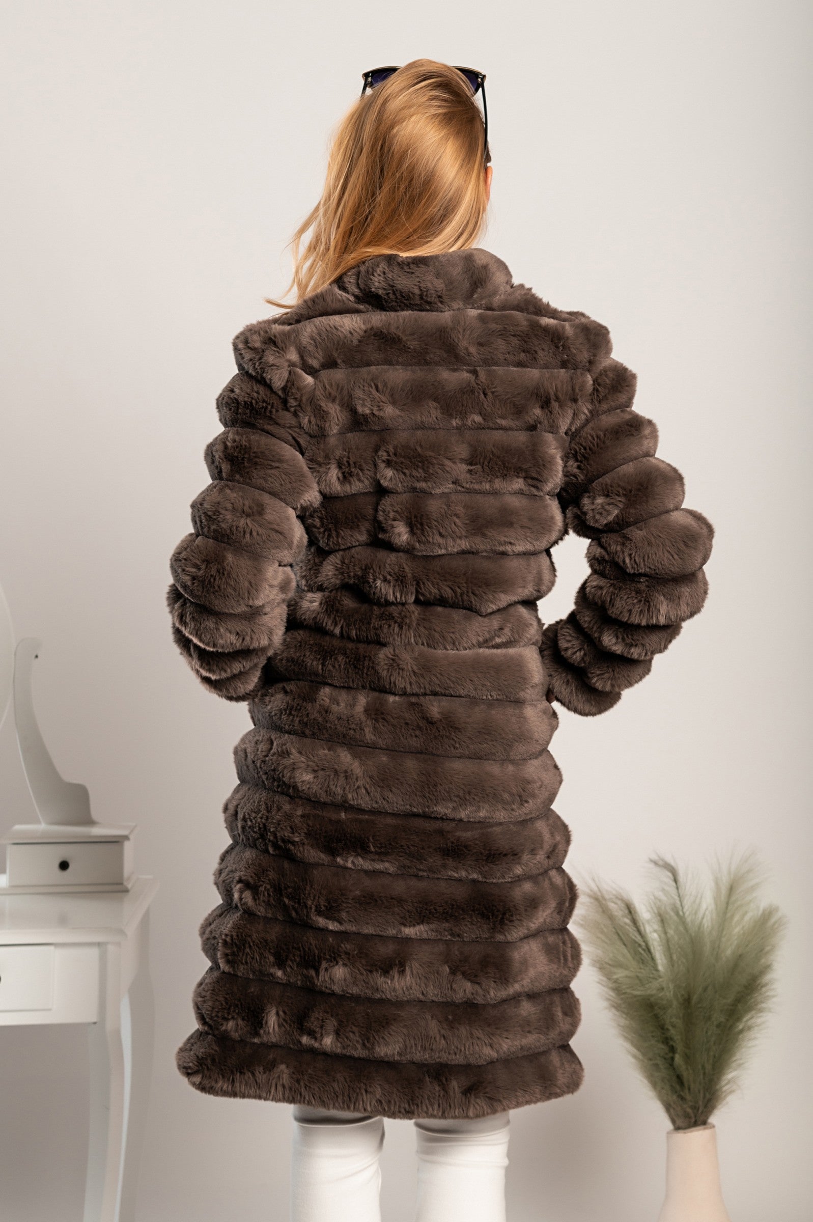 Daljši eleganten plašč iz umetnega krzna Benimia v rjavi barvi, z visokim ovratnikom in dvema žepoma.