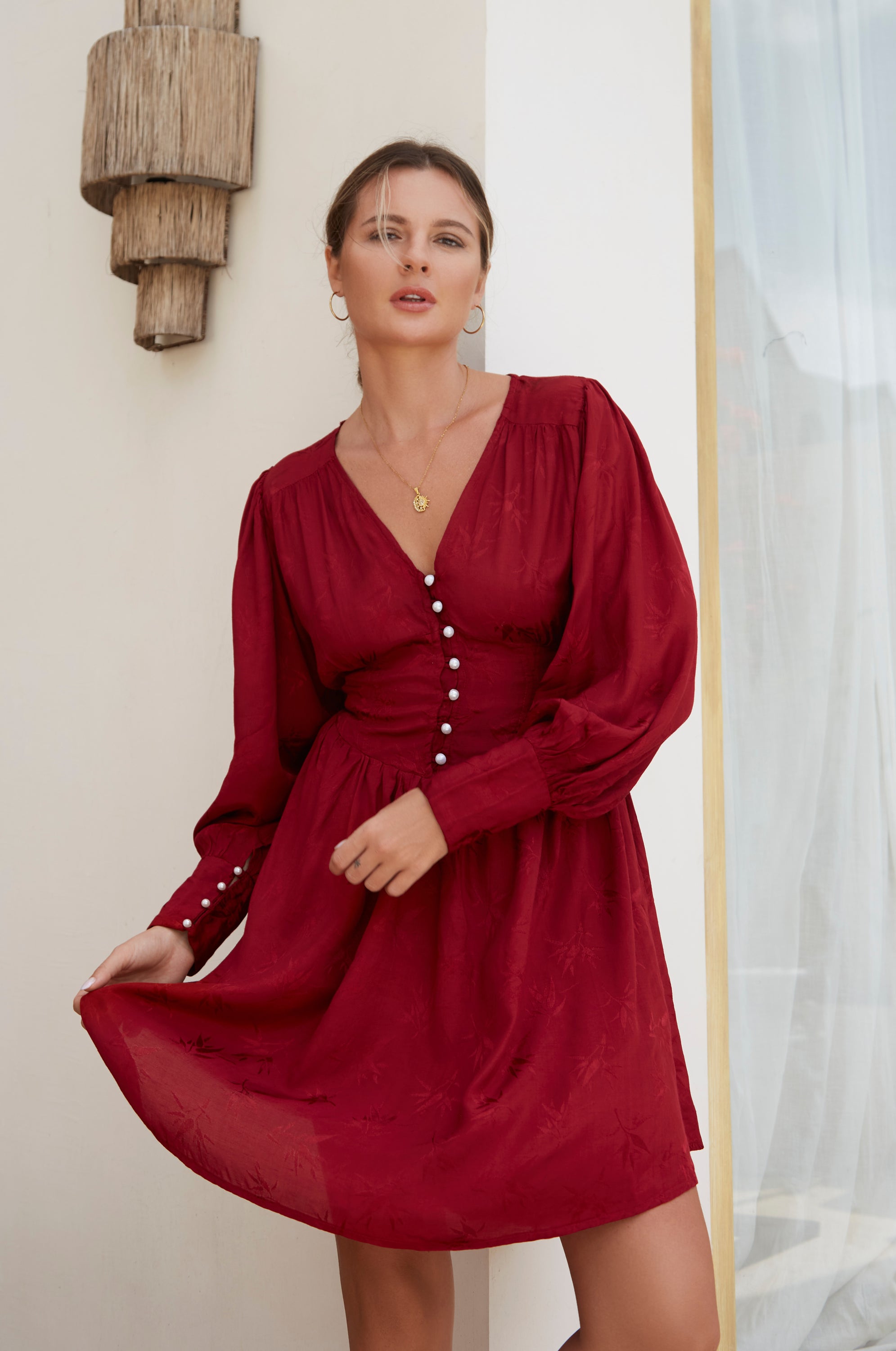 Daphne Floaty Long Sleeve Mini Dress featuring a romantic silhouette, smocked waist, voluminous sleeves, and pearl button details.