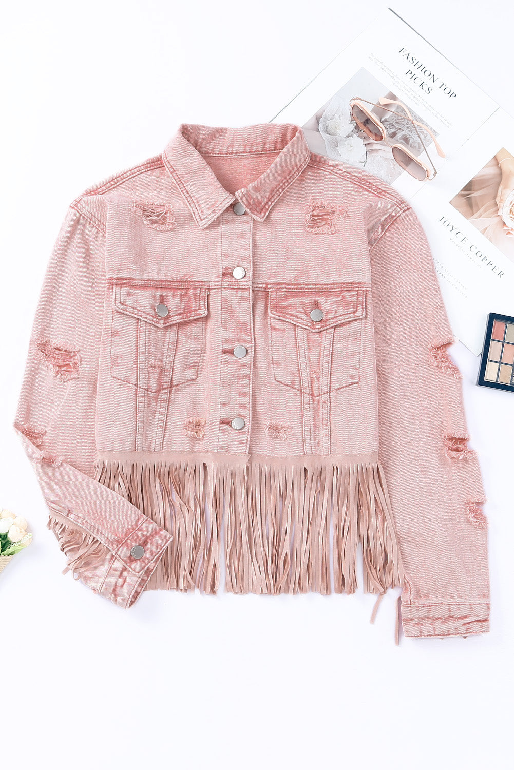 A stylish distressed denim jacket featuring fringe details, cropped length, and long sleeves, laid flat for display.