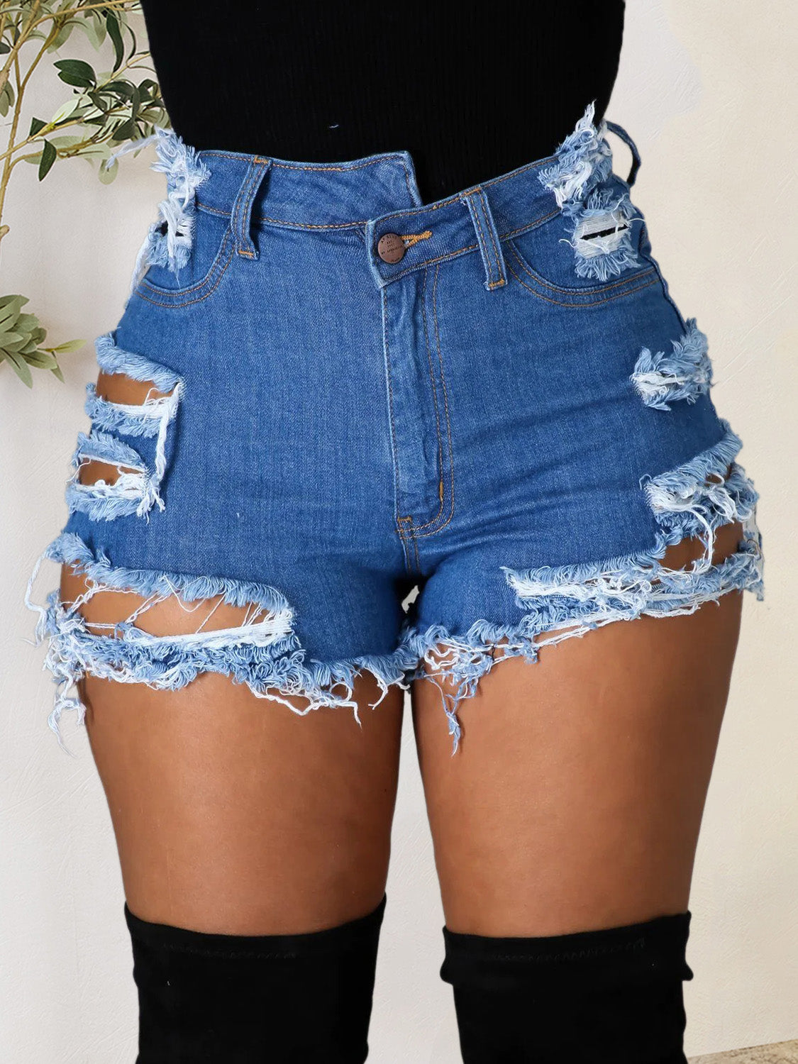 A pair of distressed raw hem denim shorts with pockets, showcasing a trendy design and slightly stretchy fabric, perfect for summer wear.