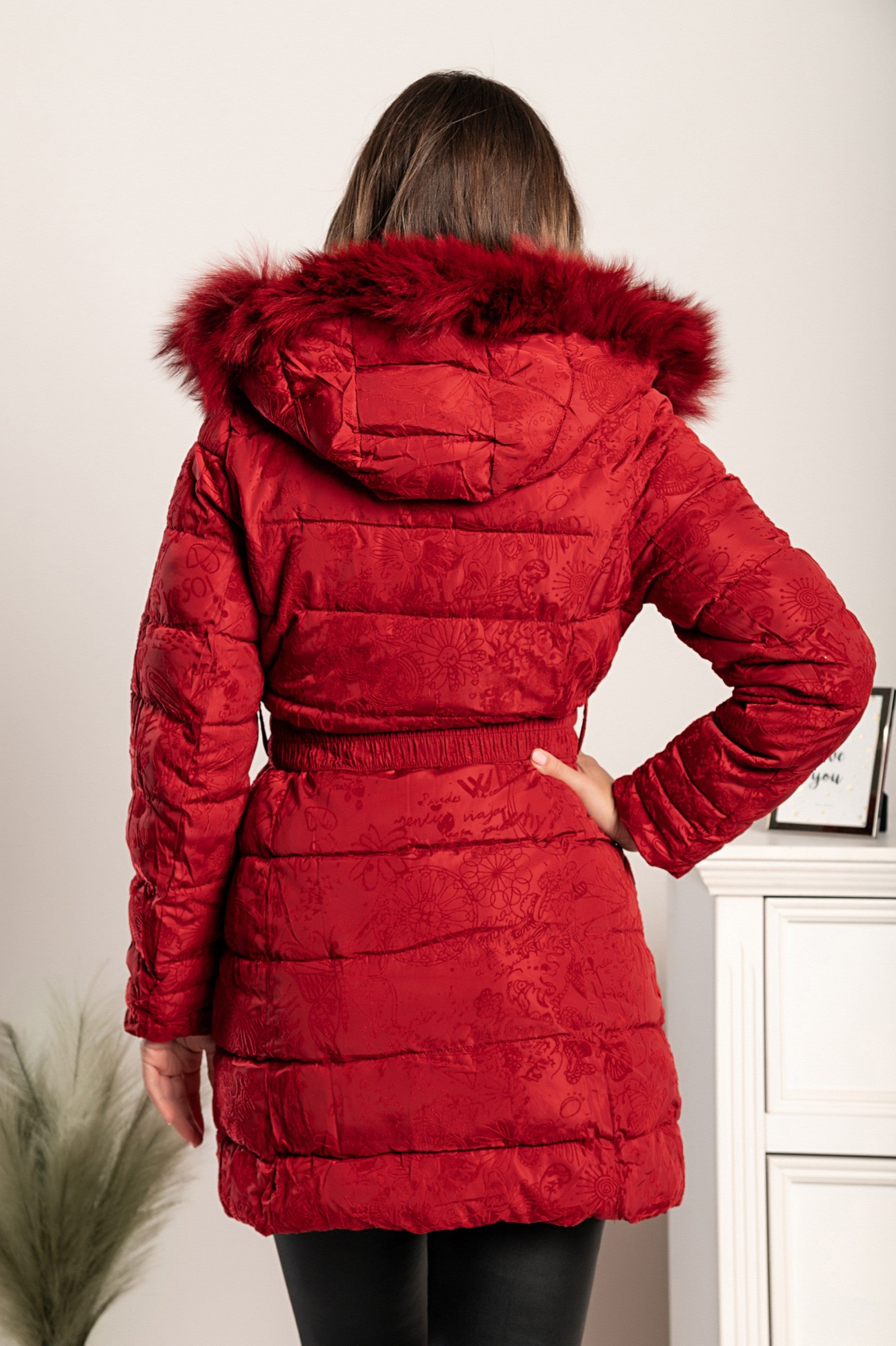 Dolga prešita bunda Remma v rdeči barvi z modrim vzorcem iz imitacije žameta, visokim ovratnikom in stranskima žepoma z zadrgo.