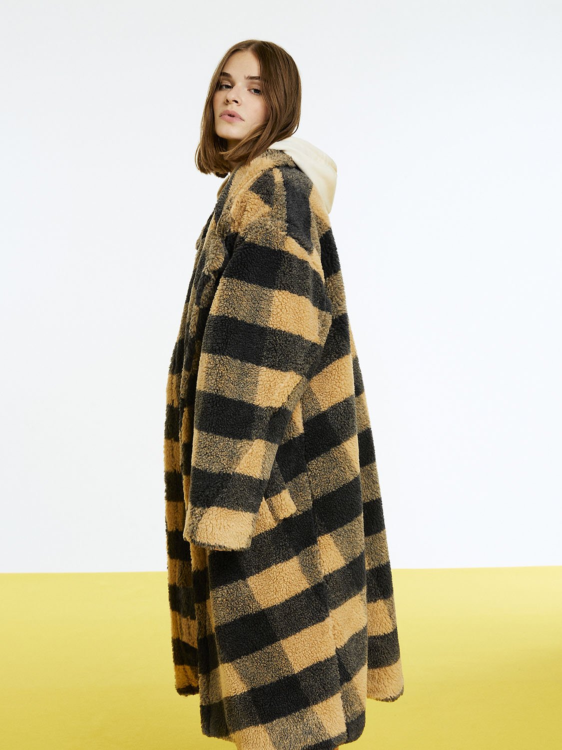 A stylish double-breasted plaid faux fur coat featuring a wide-cut design, long sleeves, and side pockets, perfect for cold weather.