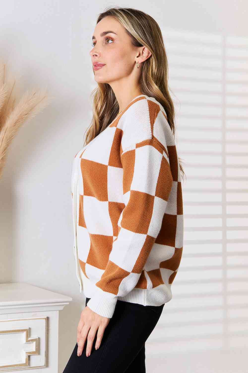 A stylish checkered button-up V-neck cardigan with dropped shoulders, showcasing its trendy design and cozy fit.