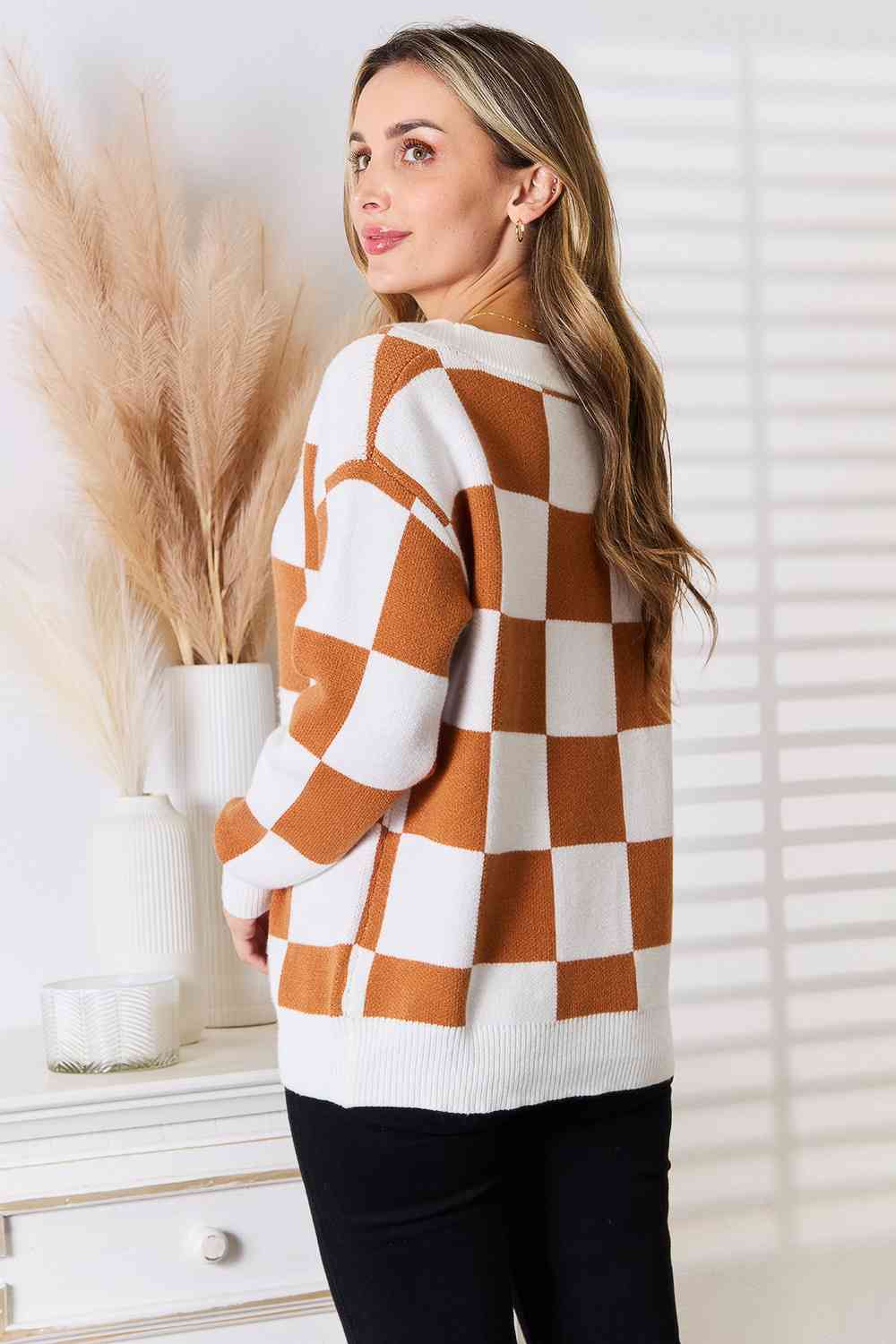 A stylish checkered button-up V-neck cardigan with dropped shoulders, showcasing its trendy design and cozy fit.
