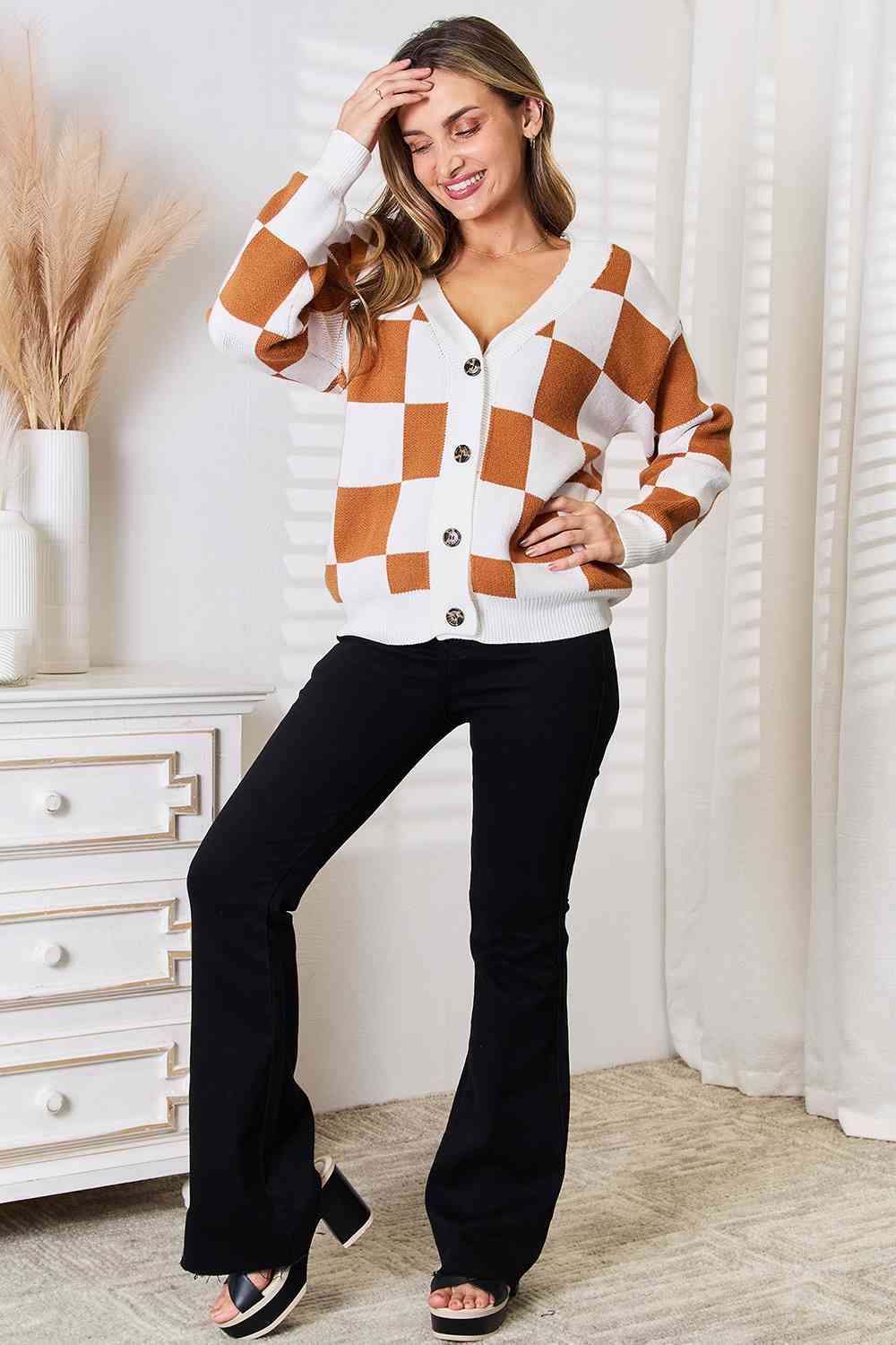 A stylish checkered button-up V-neck cardigan with dropped shoulders, showcasing its trendy design and cozy fit.