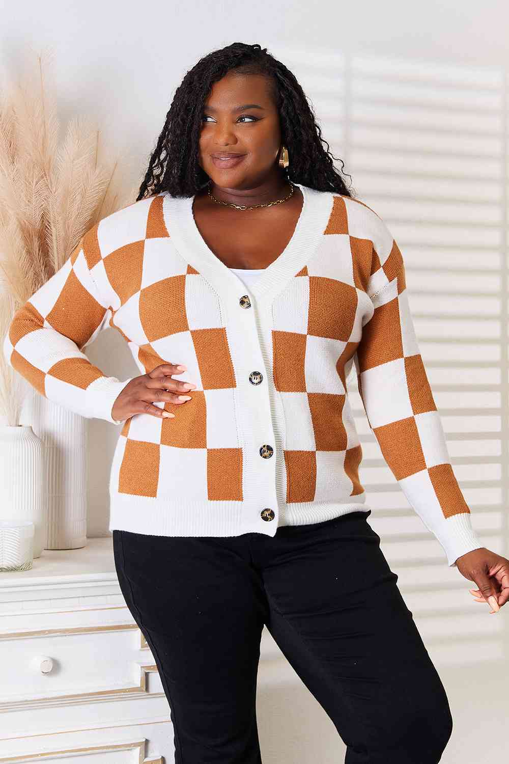 A stylish checkered button-up V-neck cardigan with dropped shoulders, showcasing its trendy design and cozy fit.