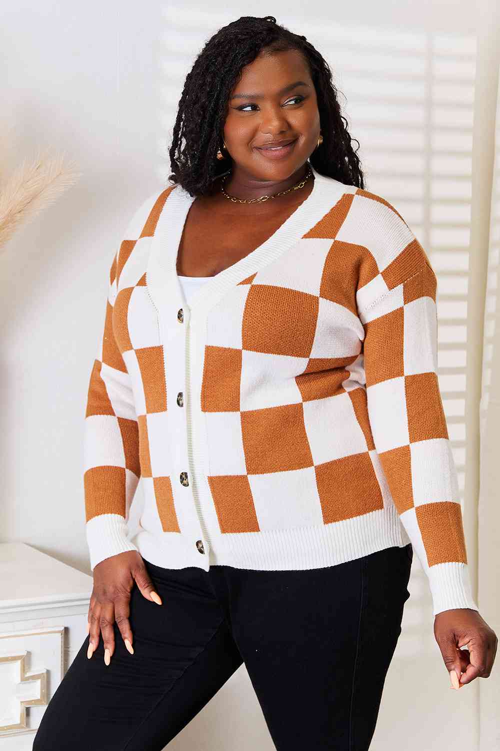A stylish checkered button-up V-neck cardigan with dropped shoulders, showcasing its trendy design and cozy fit.