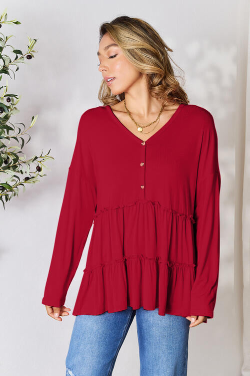 Double Take Half Button Long Sleeve Ruffle Hem Blouse in a stylish design with ruffle hem and half-button closure.