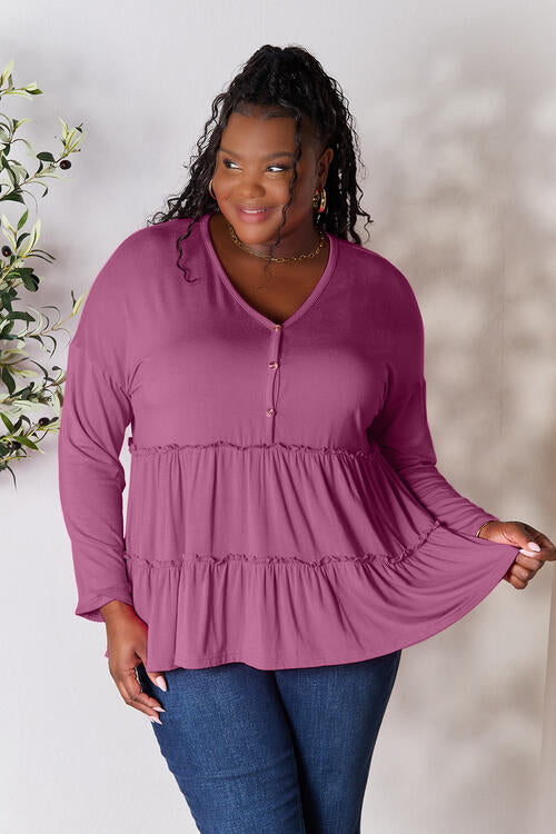 Double Take Half Button Long Sleeve Ruffle Hem Blouse in a stylish design with ruffle hem and half-button closure.