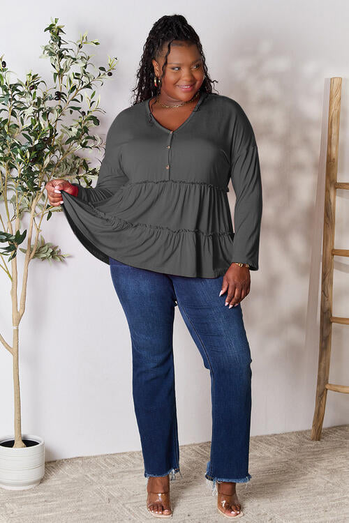 Double Take Half Button Long Sleeve Ruffle Hem Blouse in a stylish design with ruffle hem and half-button closure.