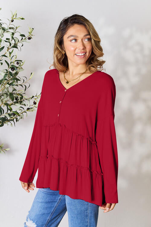 Double Take Half Button Long Sleeve Ruffle Hem Blouse in a stylish design with ruffle hem and half-button closure.