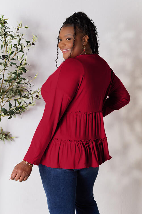 Double Take Half Button Long Sleeve Ruffle Hem Blouse in a stylish design with ruffle hem and half-button closure.