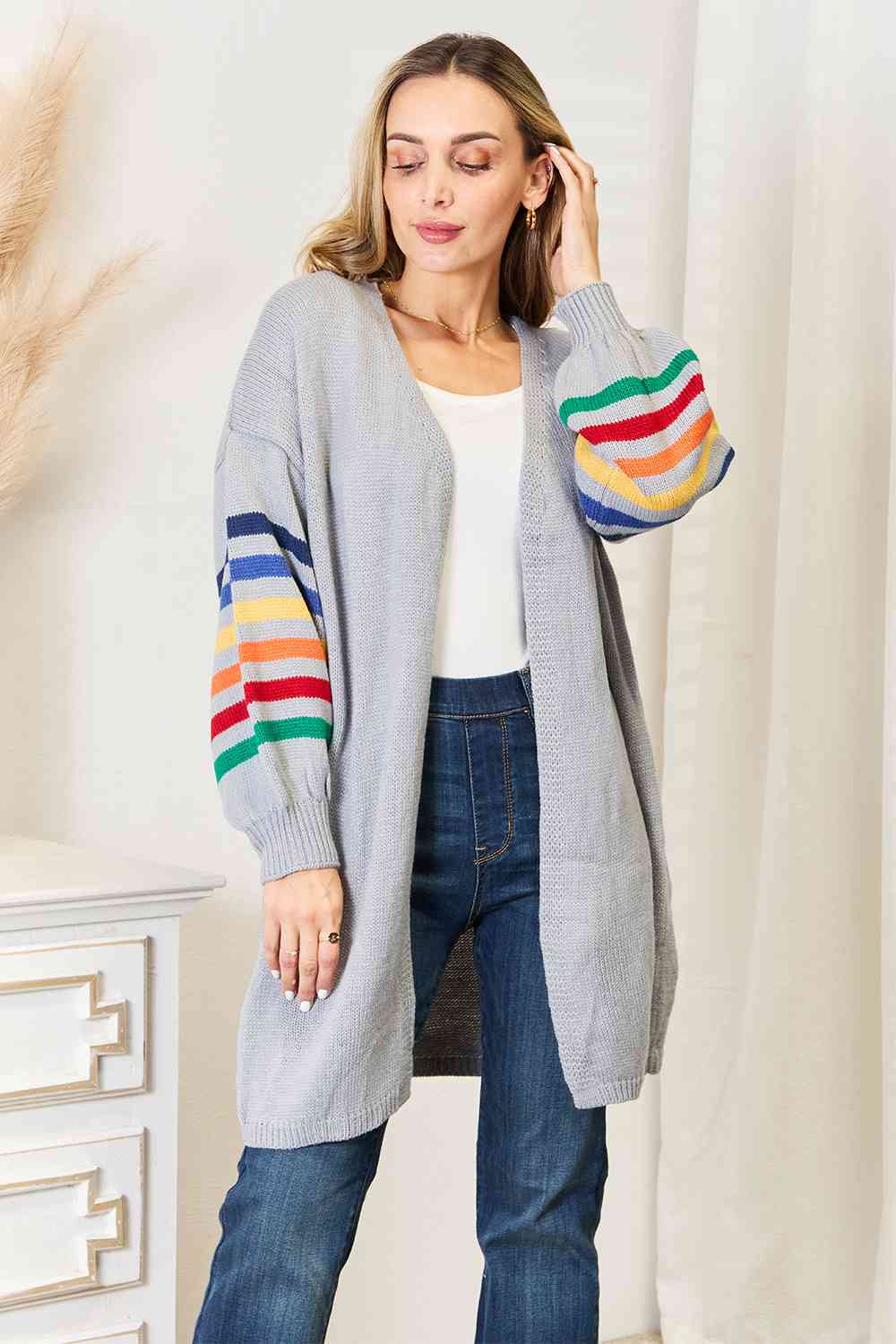 A vibrant multicolored stripe open front longline cardigan displayed on a mannequin, showcasing its stylish design and long silhouette.