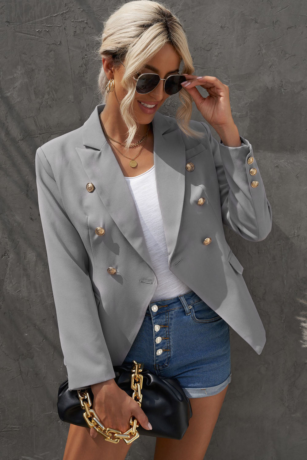 Double-breasted lapel collar blazer in solid color with pockets, displayed flat lay outdoors on a hanger.