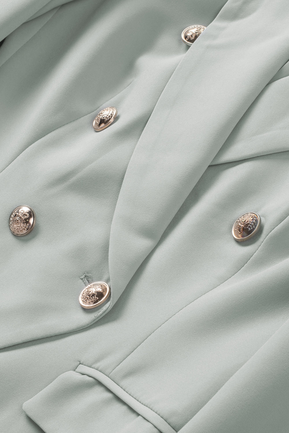 Double-breasted lapel collar blazer in solid color with pockets, displayed flat lay outdoors on a hanger.