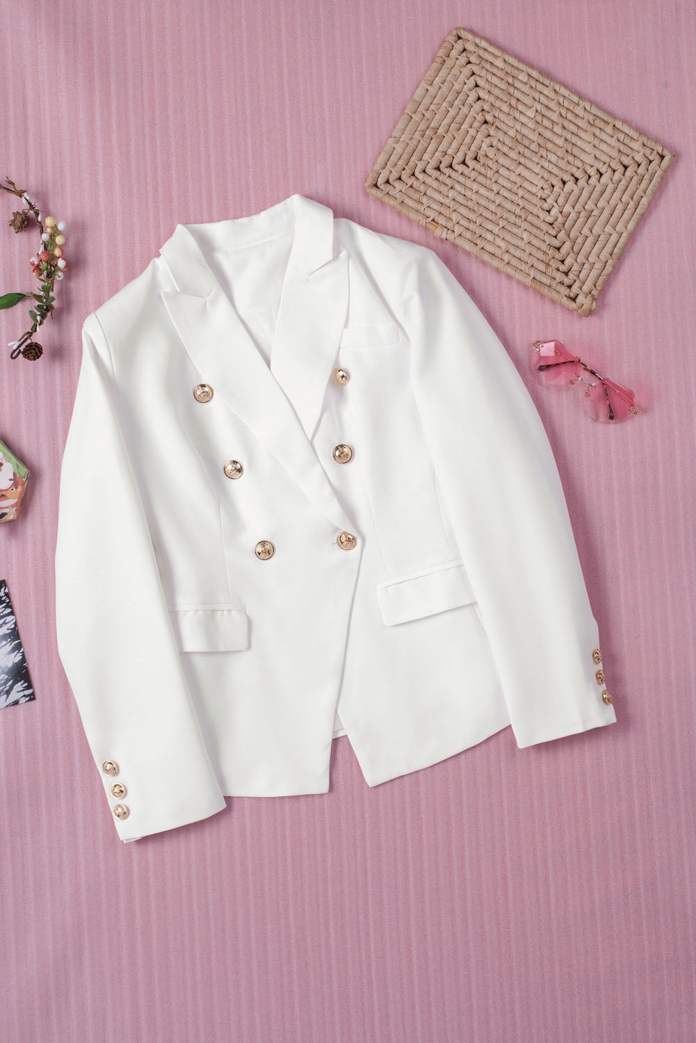 Double-breasted lapel collar blazer in solid color with pockets, displayed flat lay outdoors on a hanger.