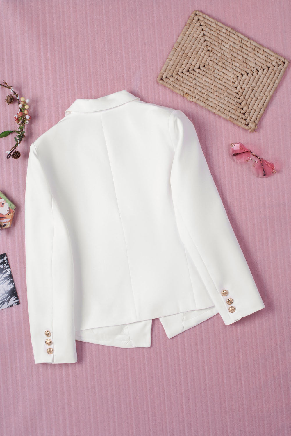 Double-breasted lapel collar blazer in solid color with pockets, displayed flat lay outdoors on a hanger.