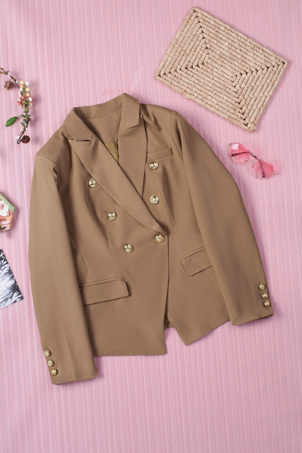 Double-breasted lapel collar blazer in solid color with pockets, displayed flat lay outdoors on a hanger.