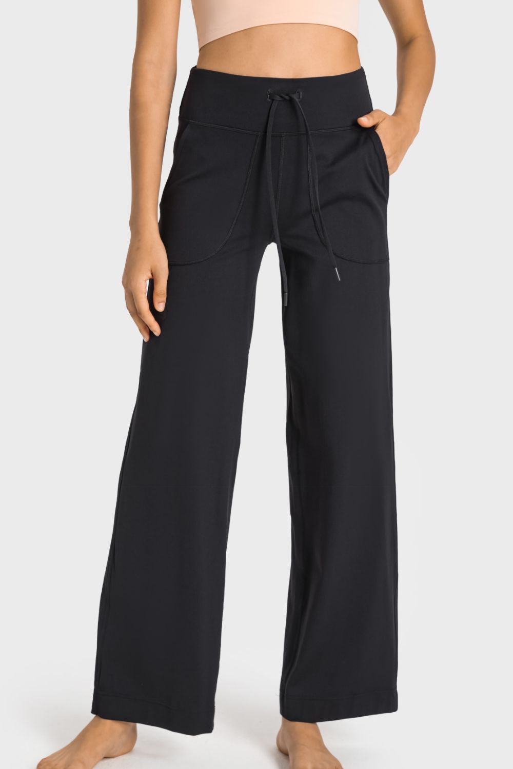 A pair of black drawstring waist wide leg sports pants with pockets, showcasing their soft fabric and stylish design.
