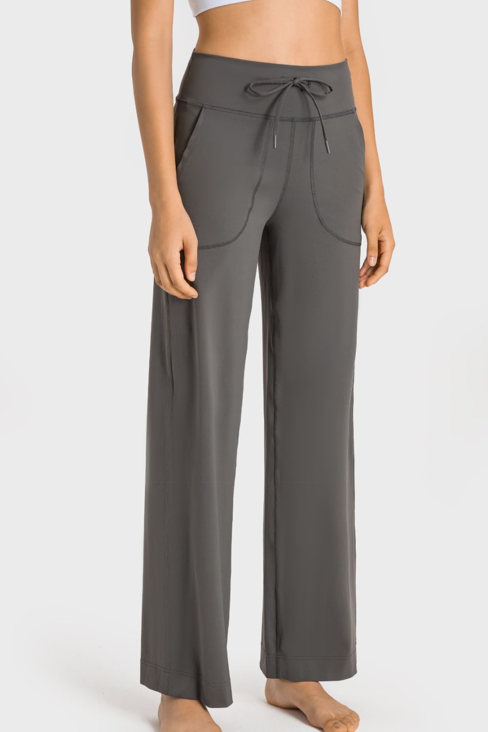 A pair of black drawstring waist wide leg sports pants with pockets, showcasing their soft fabric and stylish design.