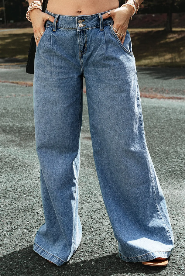 Light blue drop waist wide leg oversized jeans with button and zipper closure, featuring side pockets for added convenience.