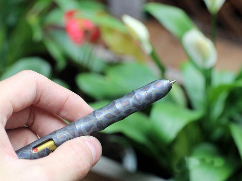EDC Outdoor Titanium TC4 Krait Tactical Pen in three finishes: Natural, Stone Wash, and Flame, showcasing its sleek design and compact size.