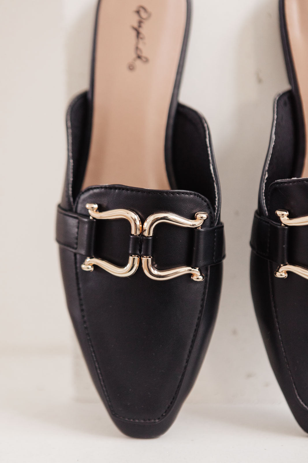 Ella Fae Slides featuring a pointed toe and gold horsebit detail, crafted from faux leather for a chic minimalist look.