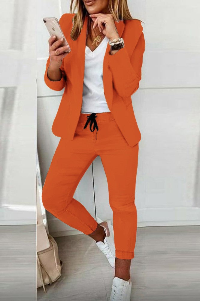 Elegant orange blazer and pants set, showcasing a classic collar and fitted trousers with drawstring waist.