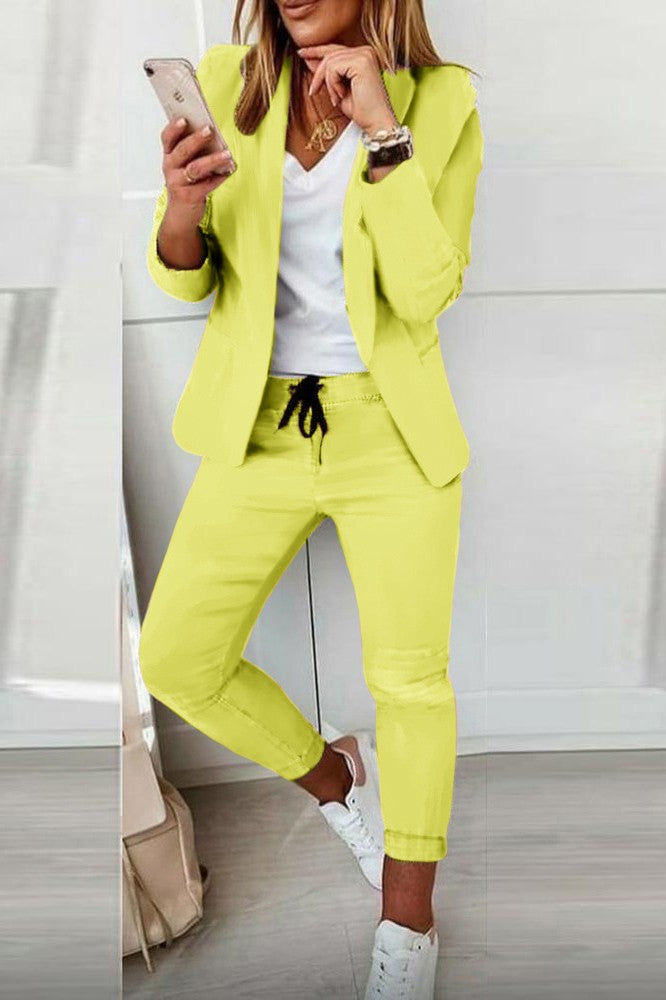 Elegant yellow blazer and pants set Estrena, featuring a classic collar, long sleeves, and fitted trousers with a drawstring waist.