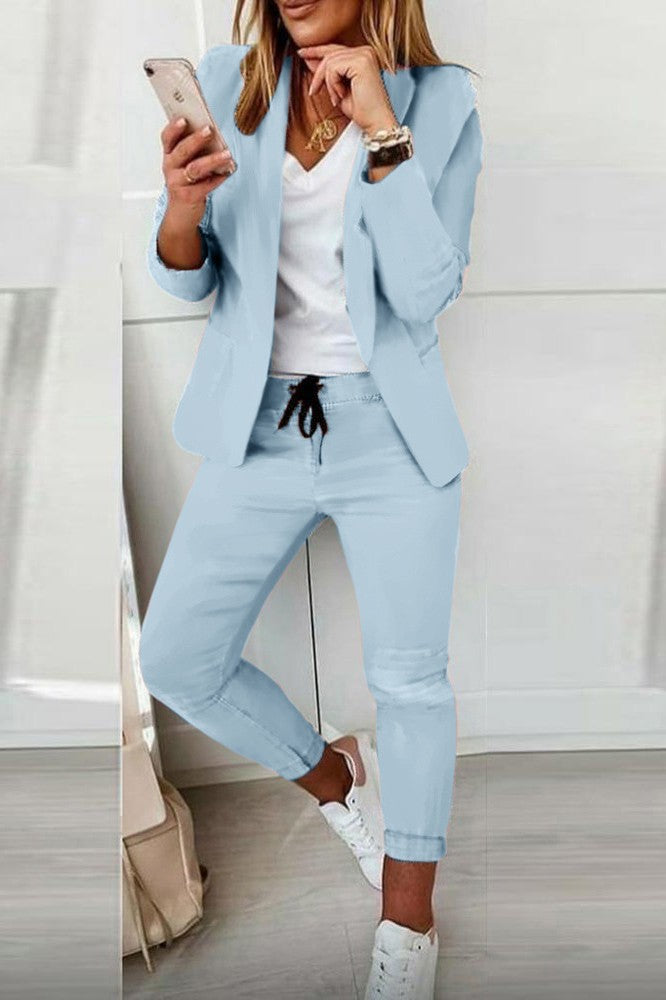 Elegant light blue blazer pants set featuring a classic collar, long sleeves, and fitted trousers with a drawstring waist.