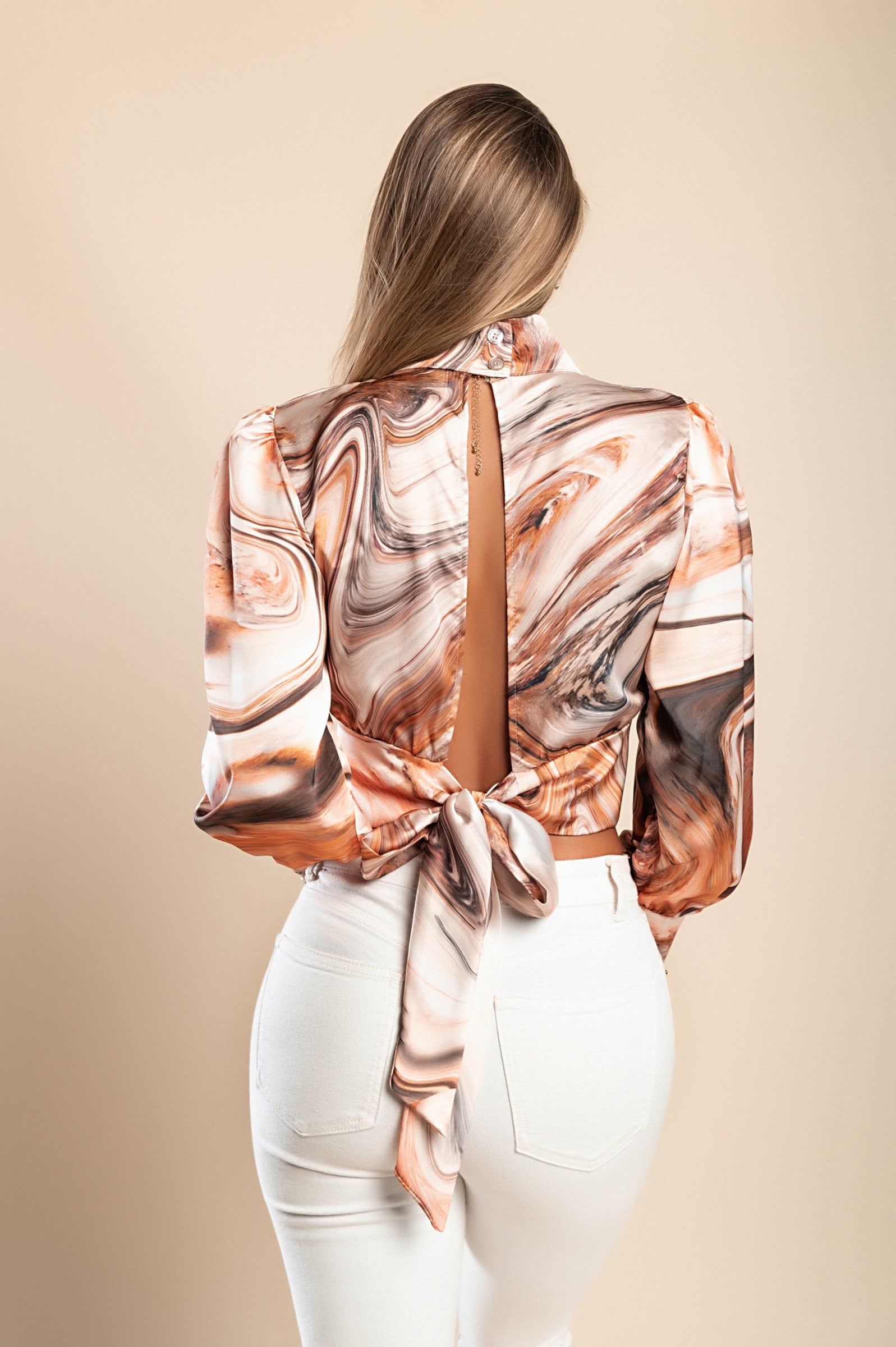 Elegant beige blouse with print Diezma featuring a high collar, long bell sleeves, and decorative ribbon tie at the back.