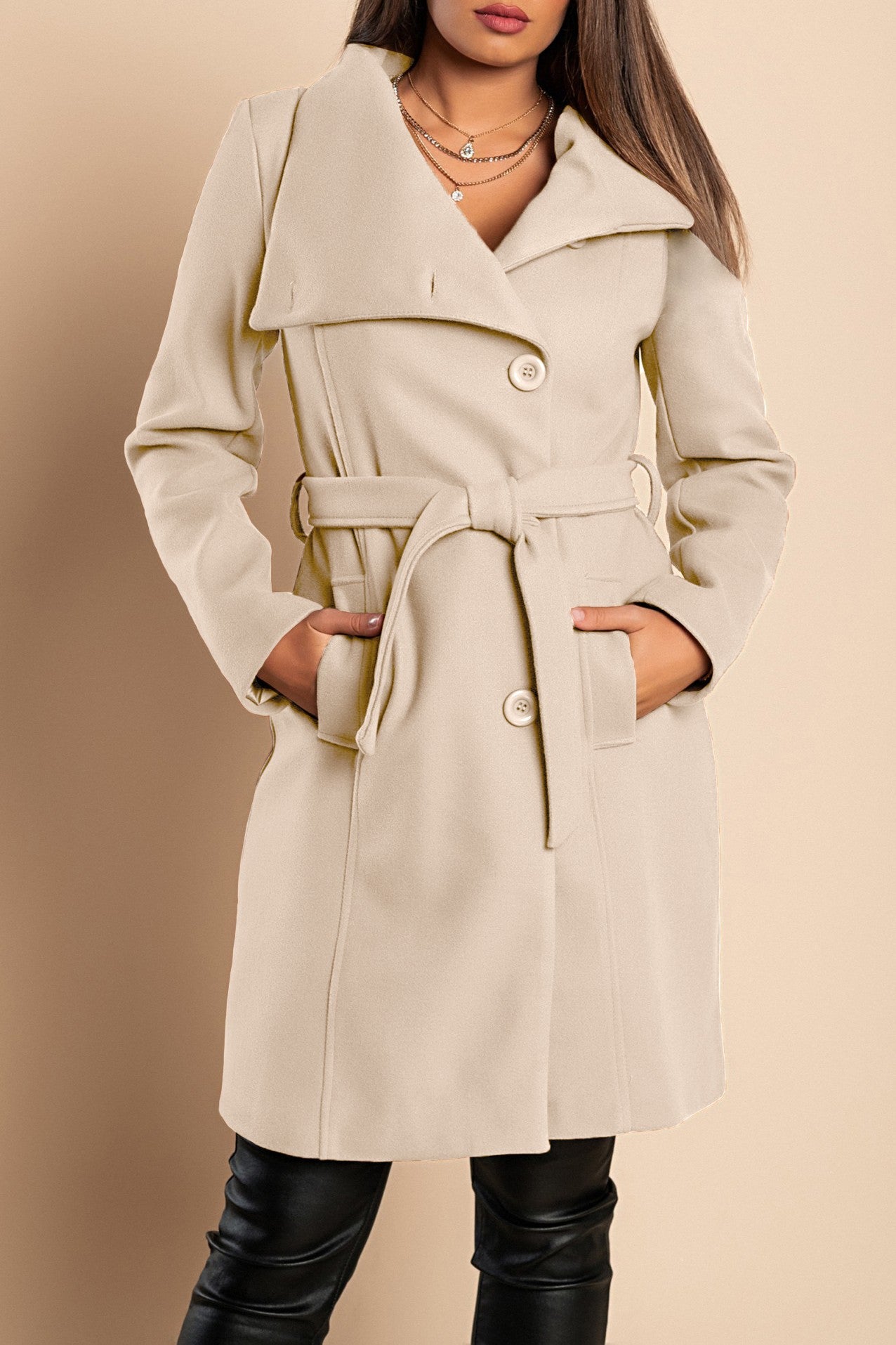 Elegant beige coat with buttons, featuring a high collar, decorative belt, and mid-thigh length, made from soft polyester fabric.