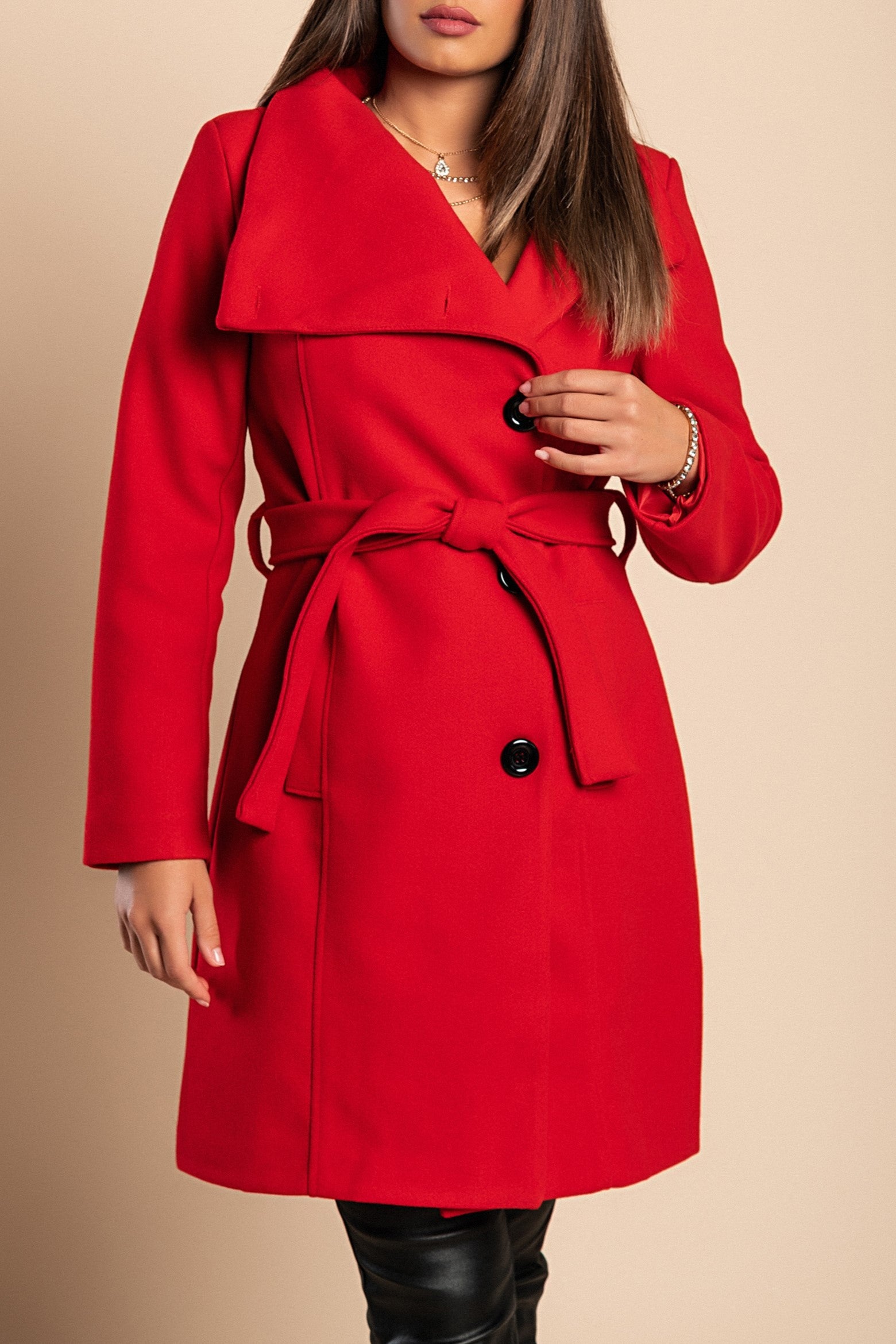 Elegant red coat with buttons, featuring a high collar, side pockets, and a decorative belt, made from soft polyester fabric.
