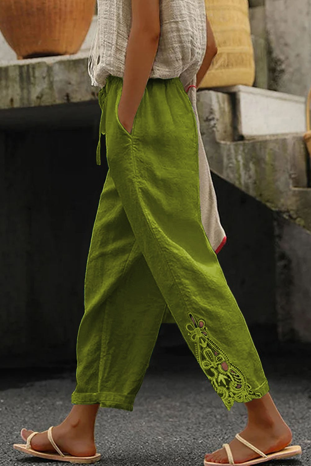 Elegant light green cotton trousers with lace detailing, featuring an elastic and drawstring waist, perfect for stylish comfort.