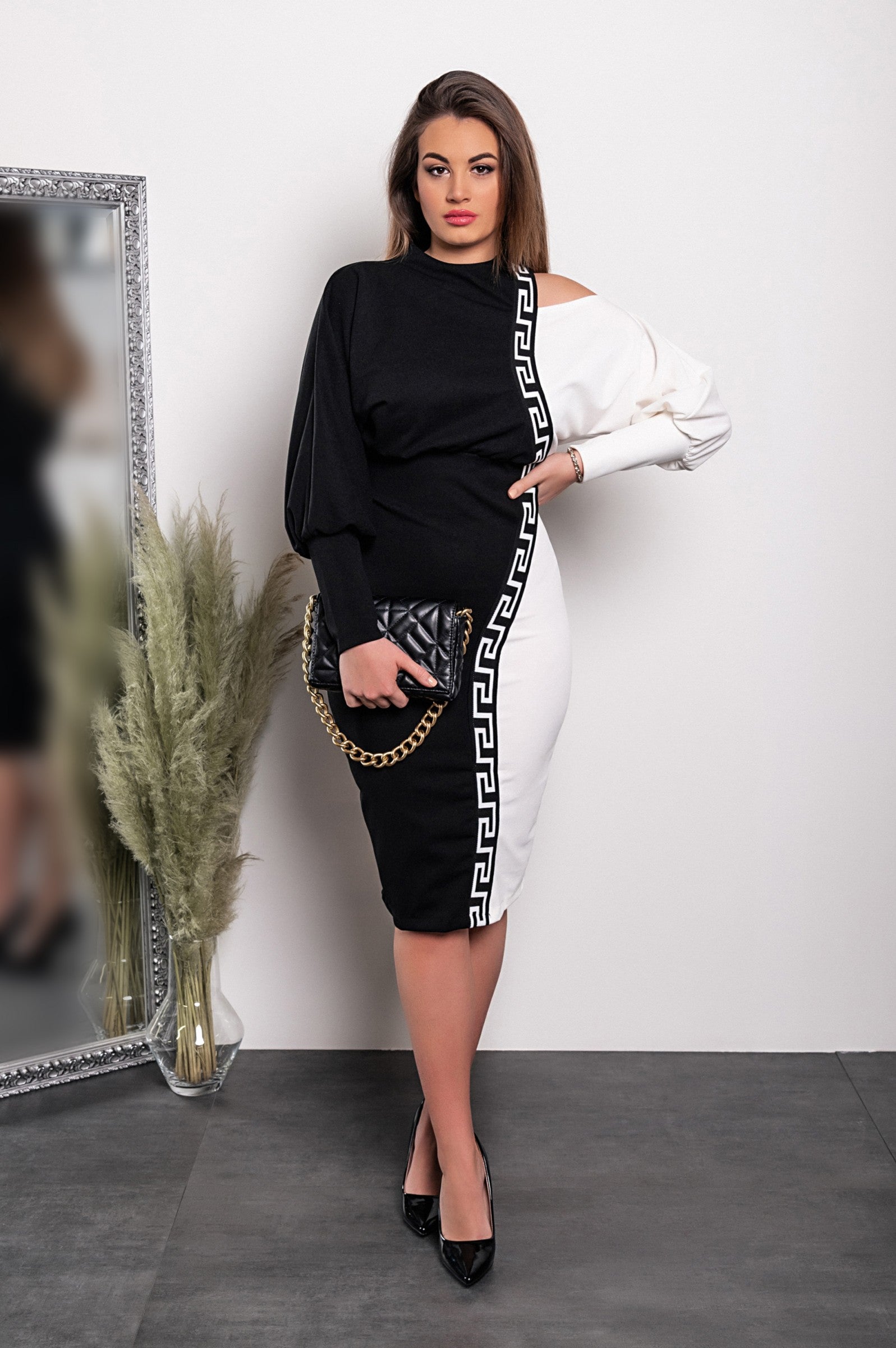 Elegant black and white geometric print midi dress featuring off-the-shoulder design and fitted knee-length skirt.