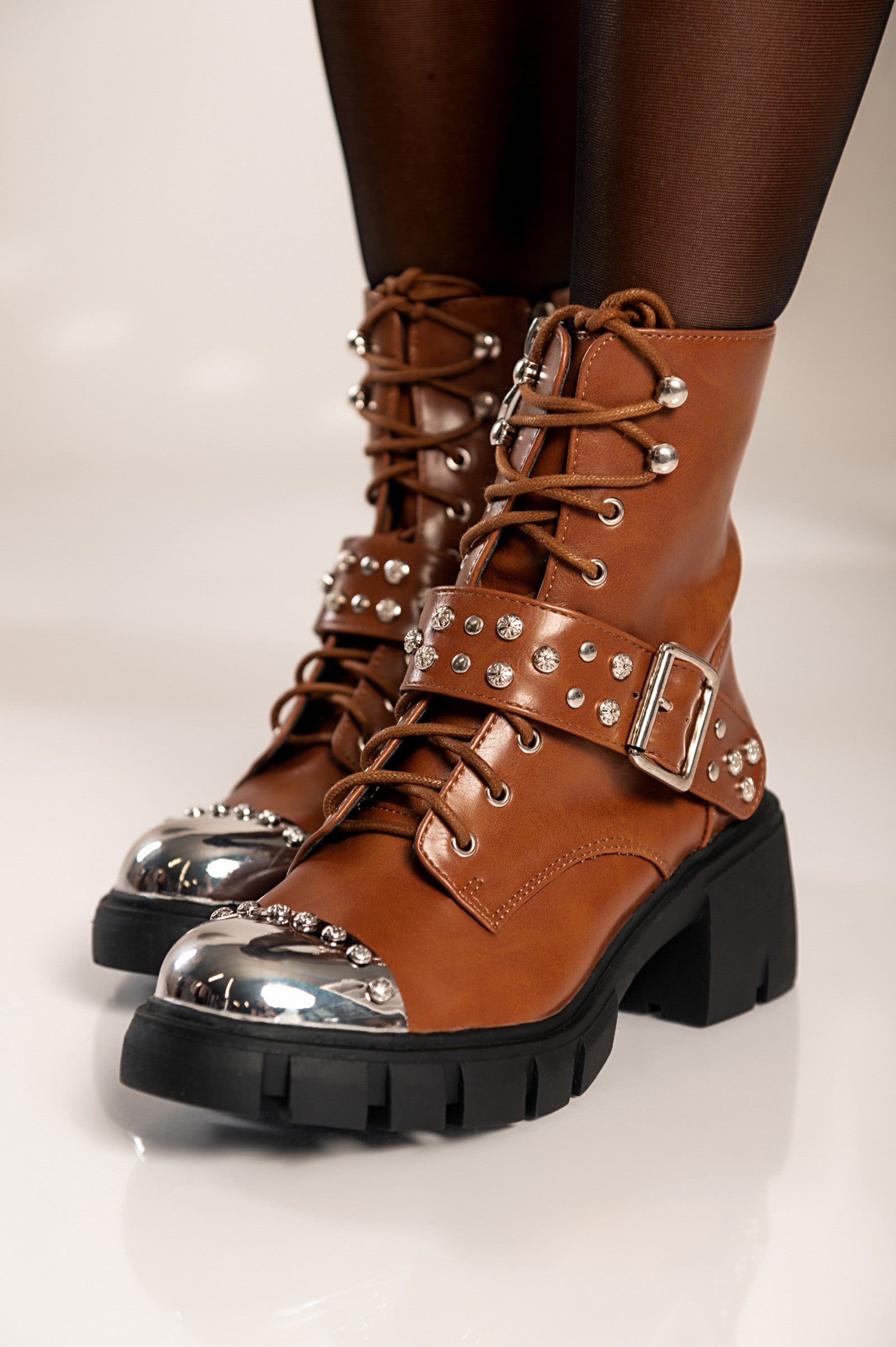 Elegant brown heeled ankle boots Coria with round toe, metal cap, and decorative bows.